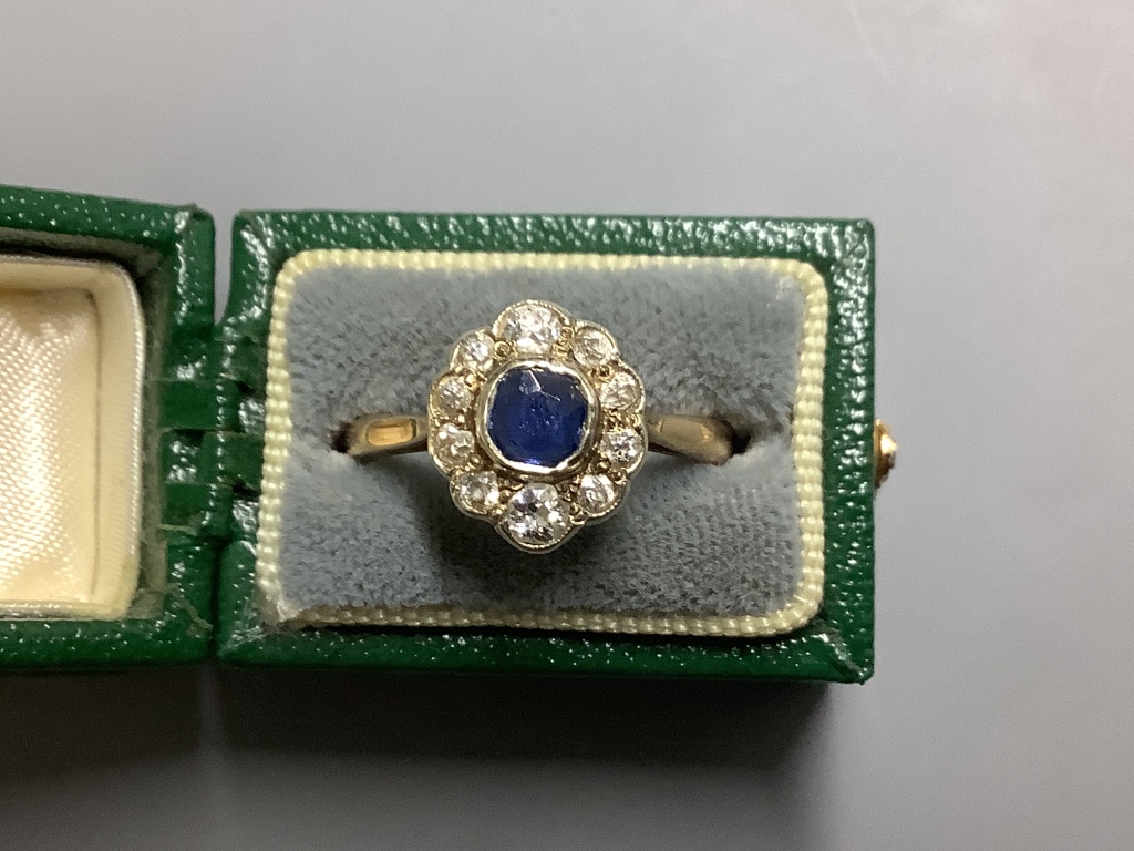 An 18ct, sapphire and diamond set oval cluster ring